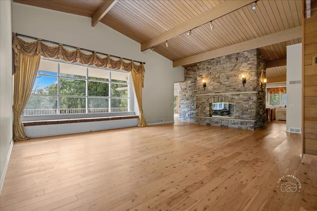 a view of empty room with wooden floor and fireplace