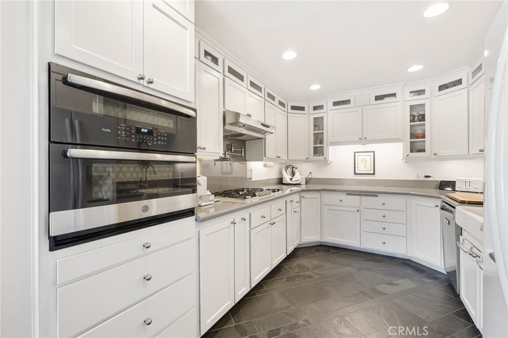 60206 Devils Ladder Road Mountain Center, CA 92561 - Photo 11 of 56 a kitchen with granite countertop white cabinets and white appliances