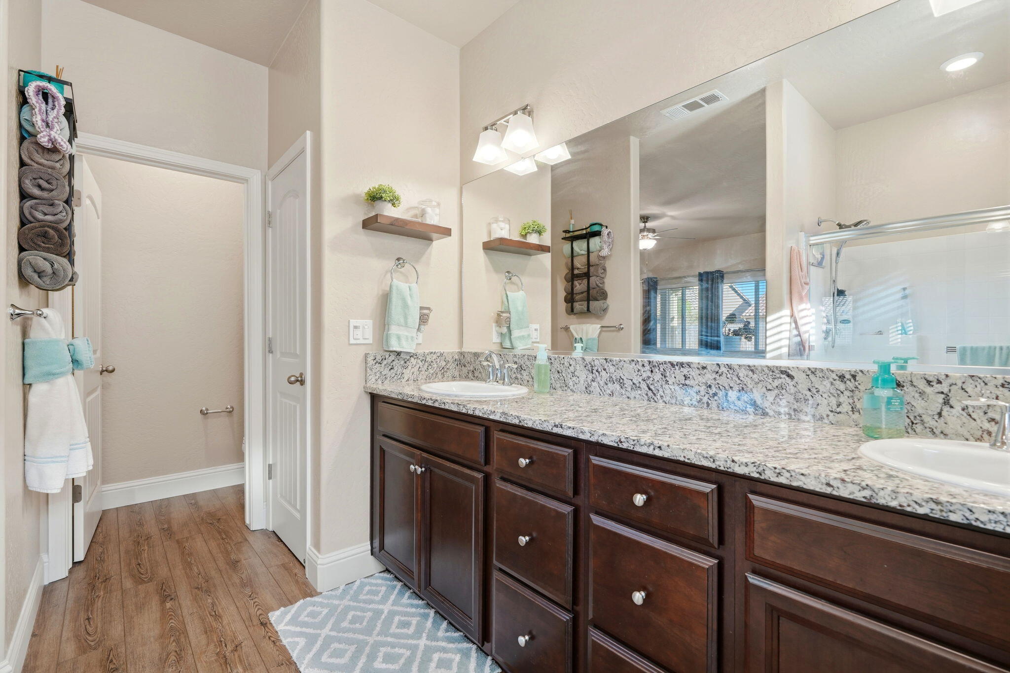 756 Strada Street Lemoore, CA 93245 - Photo 34 of 53 a bathroom with a granite countertop sink a mirror and a shower