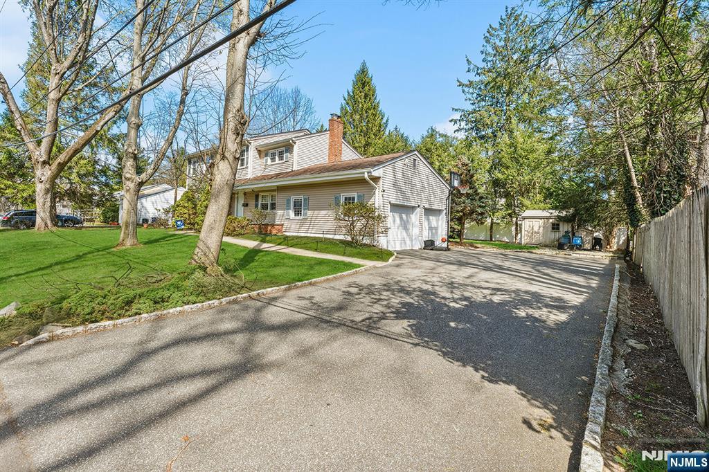 82 Van Horn Street Demarest, NJ 07627 - Photo 25 of 31 a view of a white house next to a yard with big trees