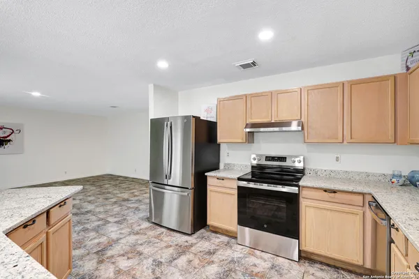 a kitchen with a refrigerator sink and cabinets