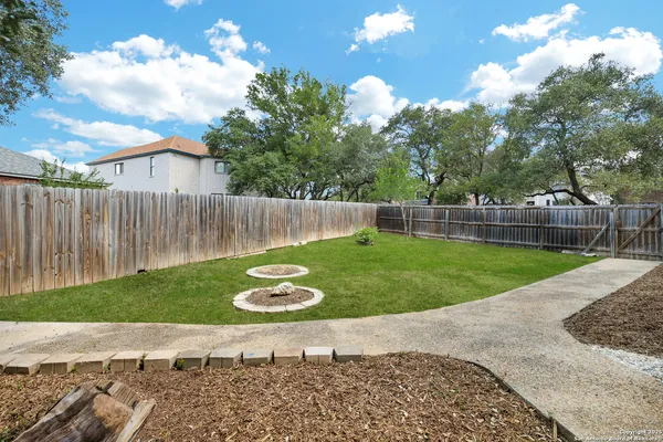 a view of a backyard with table and chairs and wooden fence