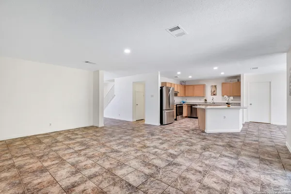 a view of kitchen with kitchen island white cabinets and refrigerator