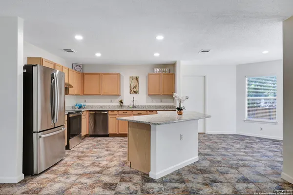 a kitchen with a refrigerator sink and cabinets
