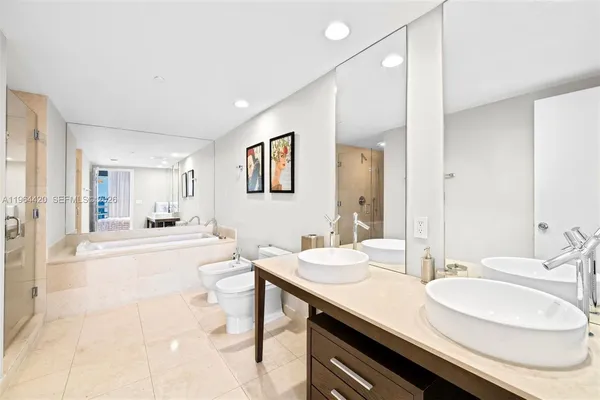 a bathroom with a granite countertop sink a toilet a mirror and vanity