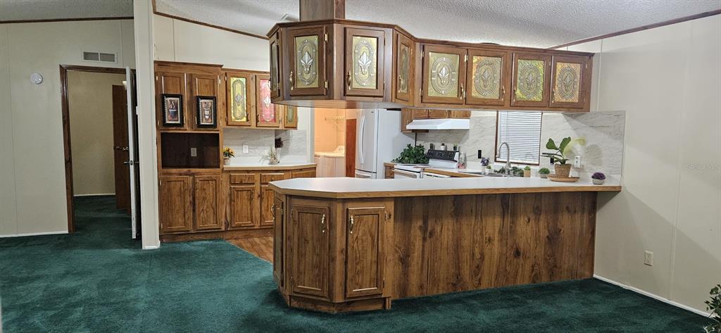 3636 South Lazy Lake Drive Lakeland, FL 33801 - Photo 11 of 28 a kitchen with stainless steel appliances granite countertop a sink a stove cabinets and a dining table