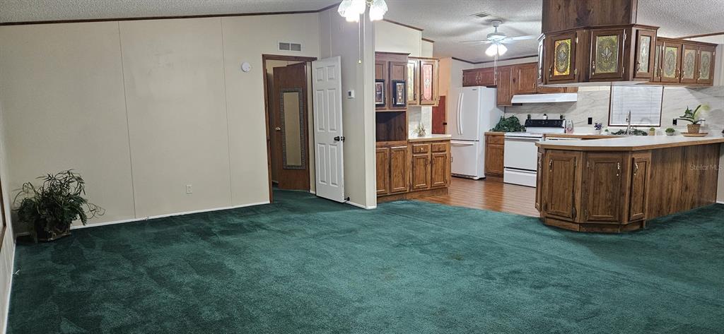 3636 South Lazy Lake Drive Lakeland, FL 33801 - Photo 10 of 28 a kitchen with kitchen island granite countertop a refrigerator a stove and a sink with wooden floor