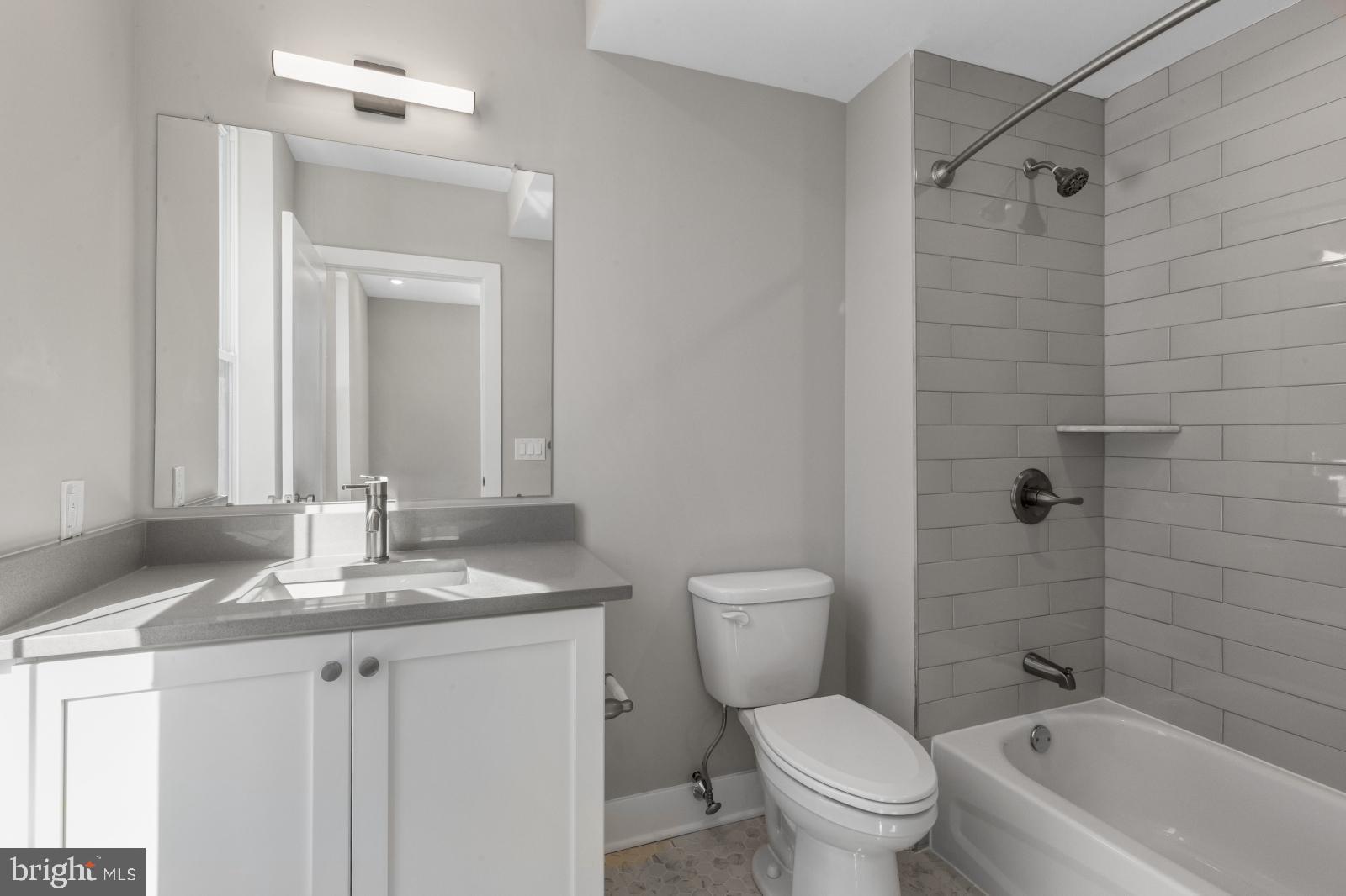 6712 Ridge Avenue, Unit 204 Philadelphia, PA 19128 - Photo 14 of 18 a bathroom with a granite countertop sink toilet and shower