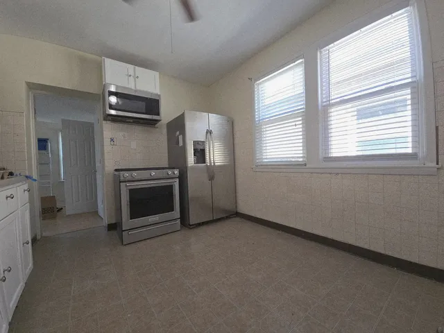 a kitchen with granite countertop white cabinets and white appliances