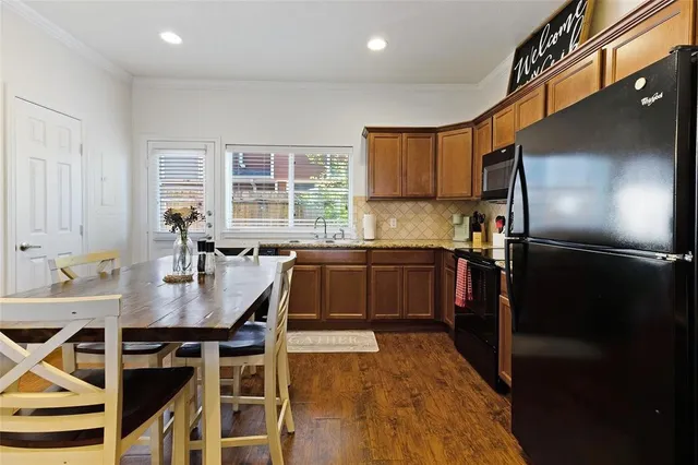 a kitchen with granite countertop a refrigerator a sink a stove and island