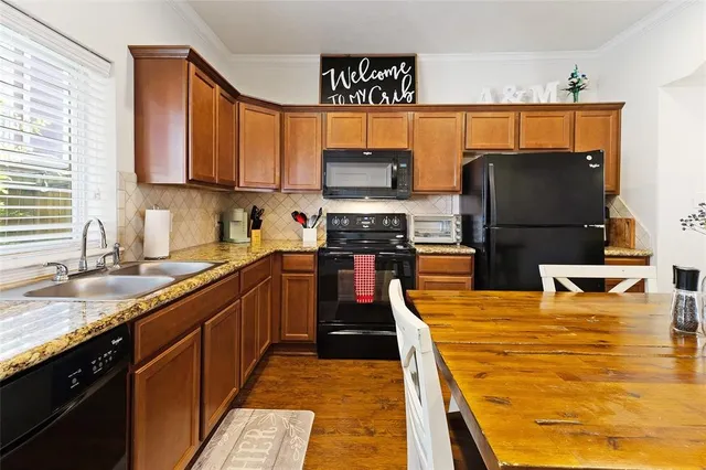 a kitchen with stainless steel appliances granite countertop a stove a sink and a microwave
