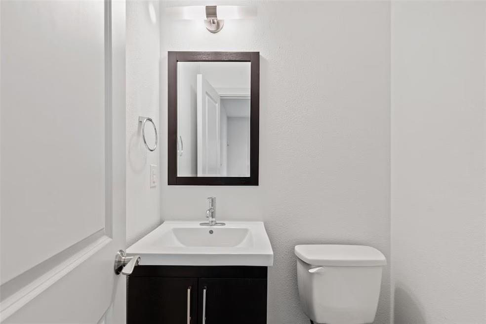 5924 Hudson Street, Unit F Dallas, TX 75206 - Photo 10 of 25 a bathroom with a toilet a sink and mirror