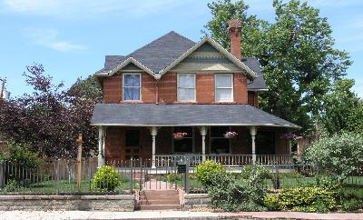 a front view of a house with plants and garden
