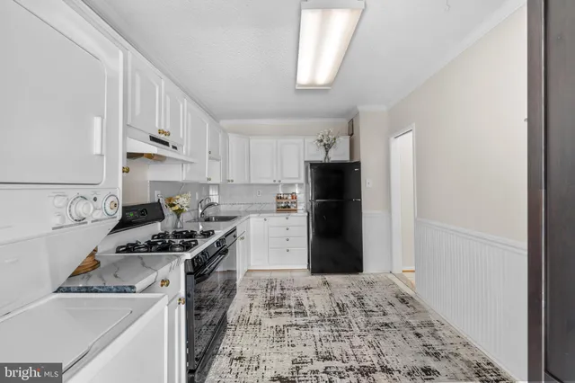 a kitchen with a stove a refrigerator and cabinets