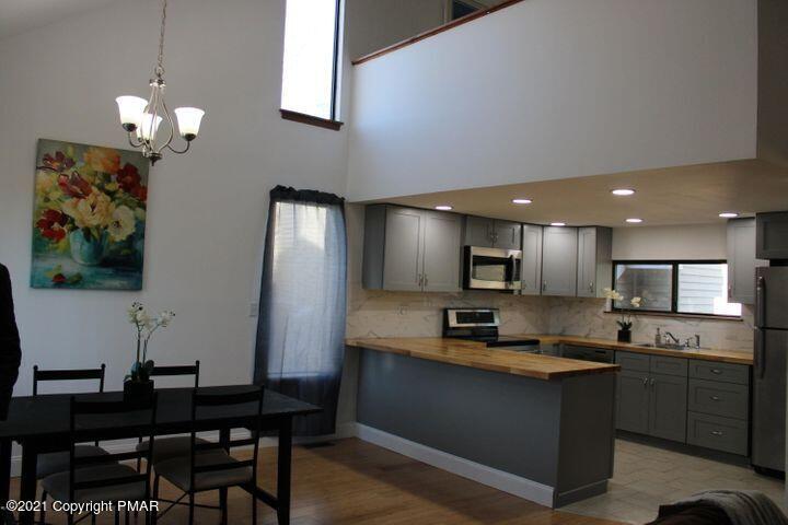 3318 Windermere Drive Bushkill, PA 18324 - Photo 11 of 35 a kitchen with a dining table chairs and a refrigerator