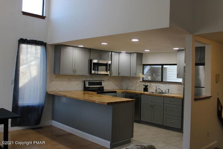 3318 Windermere Drive Bushkill, PA 18324 - Photo 12 of 35 a kitchen with stainless steel appliances granite countertop a sink a stove and refrigerator