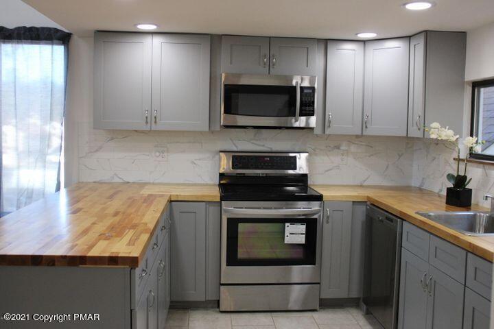 3318 Windermere Drive Bushkill, PA 18324 - Photo 4 of 35 a kitchen with granite countertop a stove and a sink