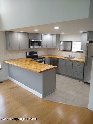3318 Windermere Drive Bushkill, PA 18324 - Photo 6 of 35 a large kitchen with stainless steel appliances granite countertop a sink counter space and a refrigerator