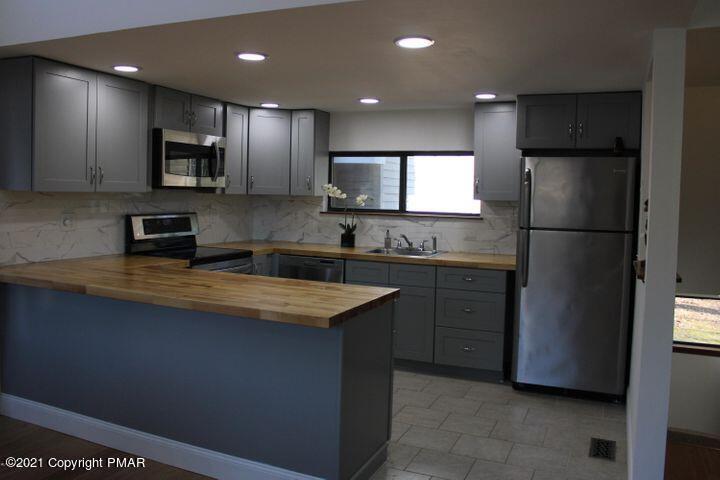 3318 Windermere Drive Bushkill, PA 18324 - Photo 7 of 35 a kitchen with stainless steel appliances granite countertop a refrigerator a stove a sink and a microwave