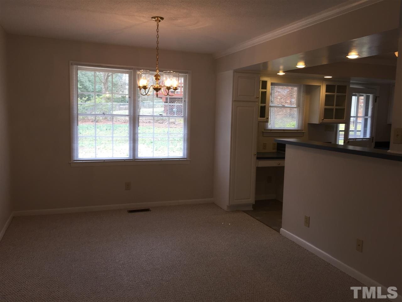 909 Hardimont Road Raleigh, NC 27609 - Photo 4 of 9 an empty room with windows and chandelier