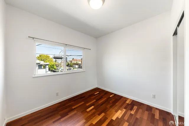a view of a room with wooden floor