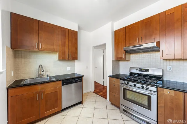 a kitchen with granite countertop cabinets and black appliances