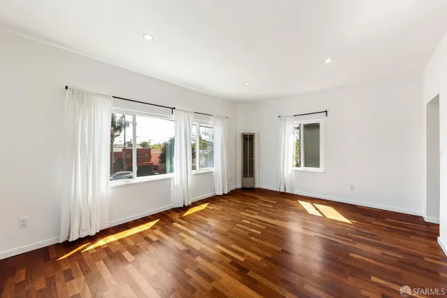 a view of empty room with wooden floor