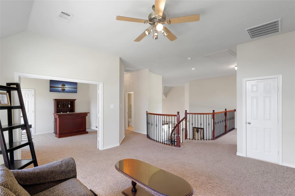 10414 Broadmoor Lane Rowlett, TX 75089 - Photo 20 of 38 Living area with ceiling fan, an upstairs landing, light colored carpet, and vaulted ceiling