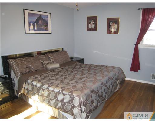 7 Butler Road Edison, NJ 08820 - Photo 9 of 18 a large bed sitting in a bedroom next to a window