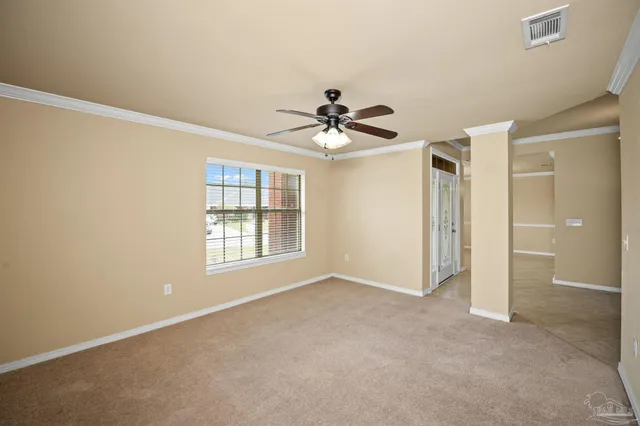 an empty room with a window and a ceiling fan