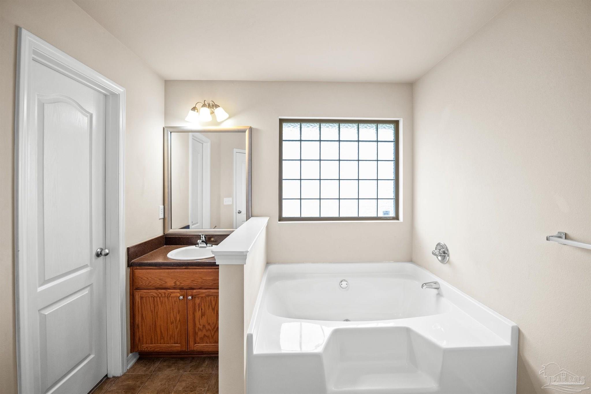 4574 Belvedere Circle Pace, FL 32571 - Photo 37 of 59 a bathroom with a tub sink and mirror