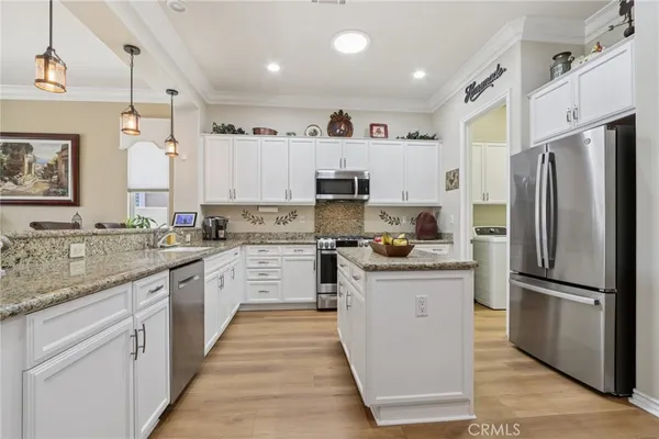 a kitchen with granite countertop white cabinets and white appliances