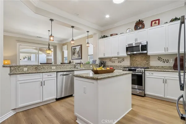 a kitchen with stainless steel appliances granite countertop a refrigerator and a sink