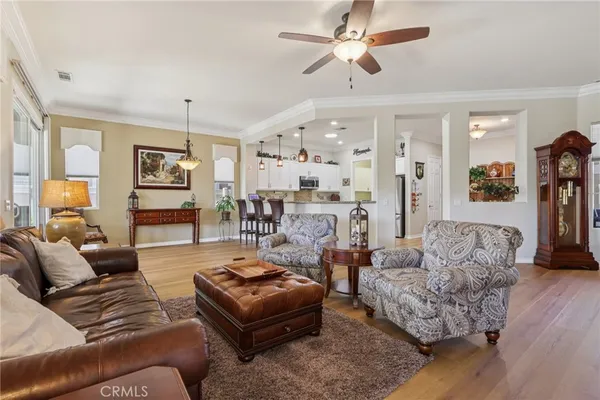 a living room with furniture ceiling fan and a flat screen tv