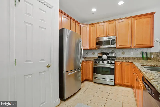 a kitchen with granite countertop a sink and white cabinets