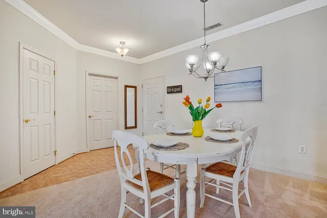 a dining room filled chandelier and kitchen view