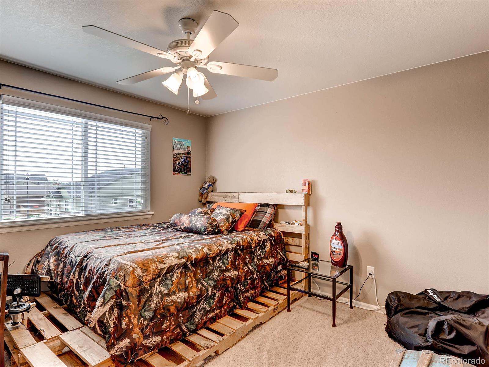 4500 Bramble Road Frederick, CO 80504 - Photo 20 of 25 a bedroom with a bed and a chandelier