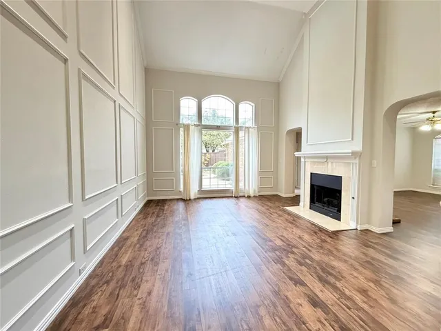 a view of a livingroom with wooden floor a fireplace and windows
