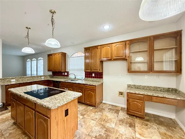 a kitchen with a stove sink and cabinets