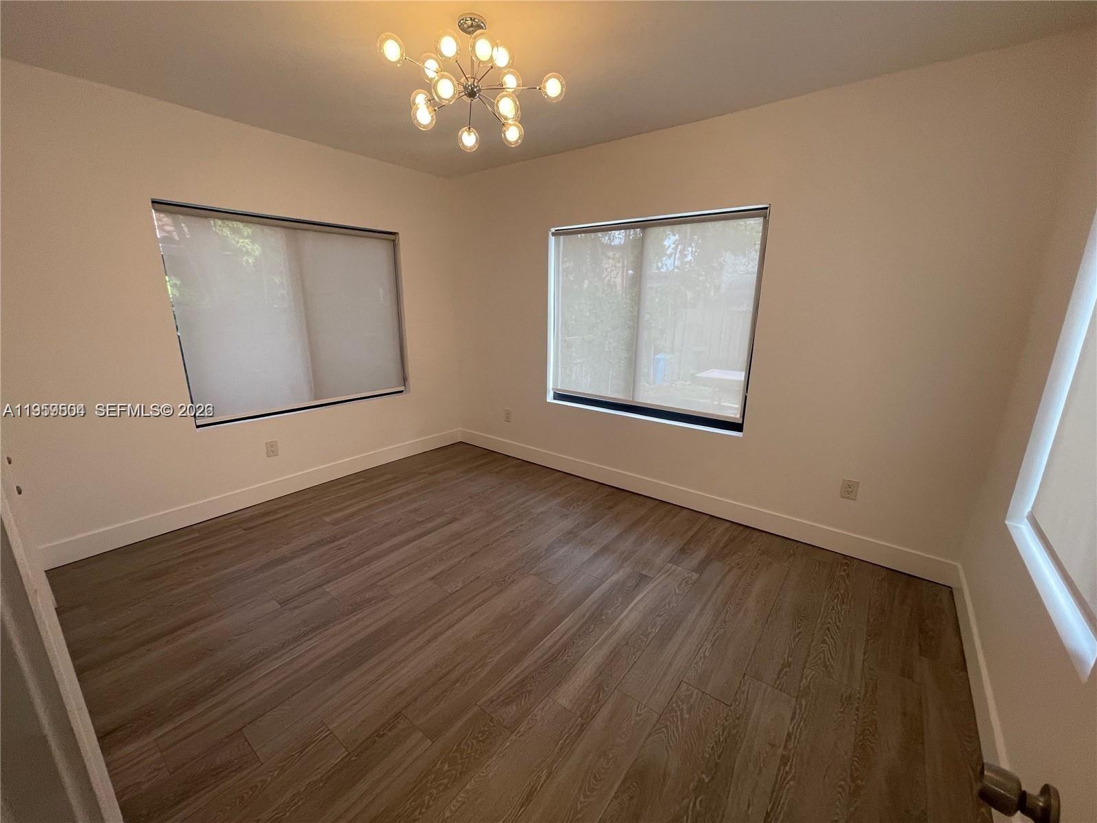 1637 Southwest 10th Street, Unit 2 Miami, FL 33135 - Photo 7 of 9 a view of an empty room with wooden floor and a window