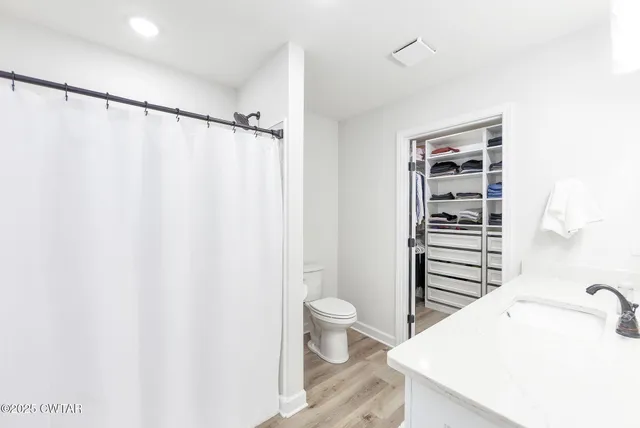 a bathroom with a shower curtain a sink and a toilet
