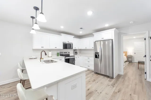 a kitchen with refrigerator cabinets and wooden floor