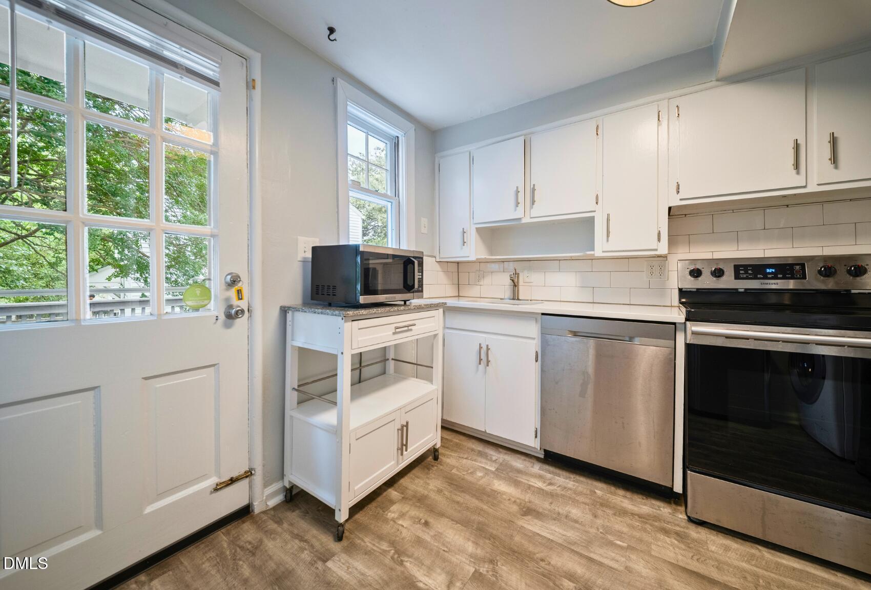 967 St Marys Street Raleigh, NC 27605 - Photo 18 of 34 a kitchen with white cabinets and white appliances