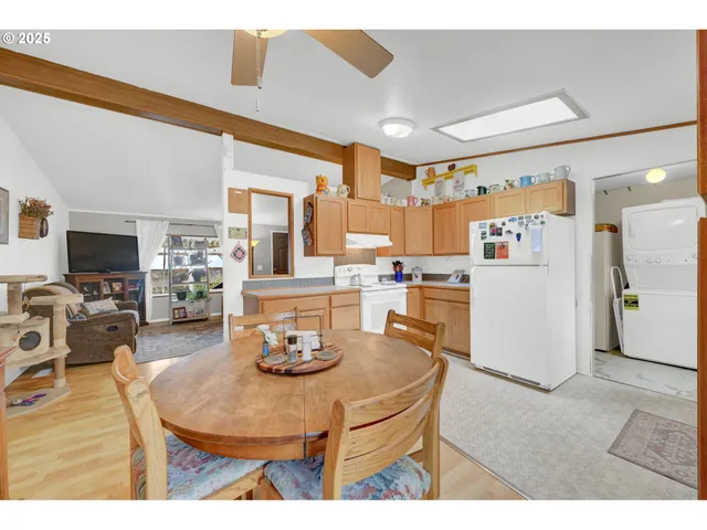 a living room with stainless steel appliances kitchen island granite countertop furniture and a flat screen tv
