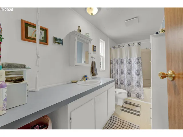 a bathroom with a sink a toilet a mirror and shower