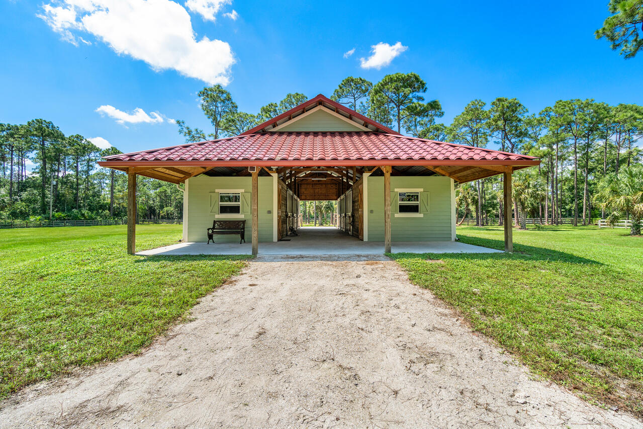 1835 Stallion Drive, Unit STALLS Loxahatchee, FL 33470 - Photo 18 of 35 a front view of a house with a yard and garage