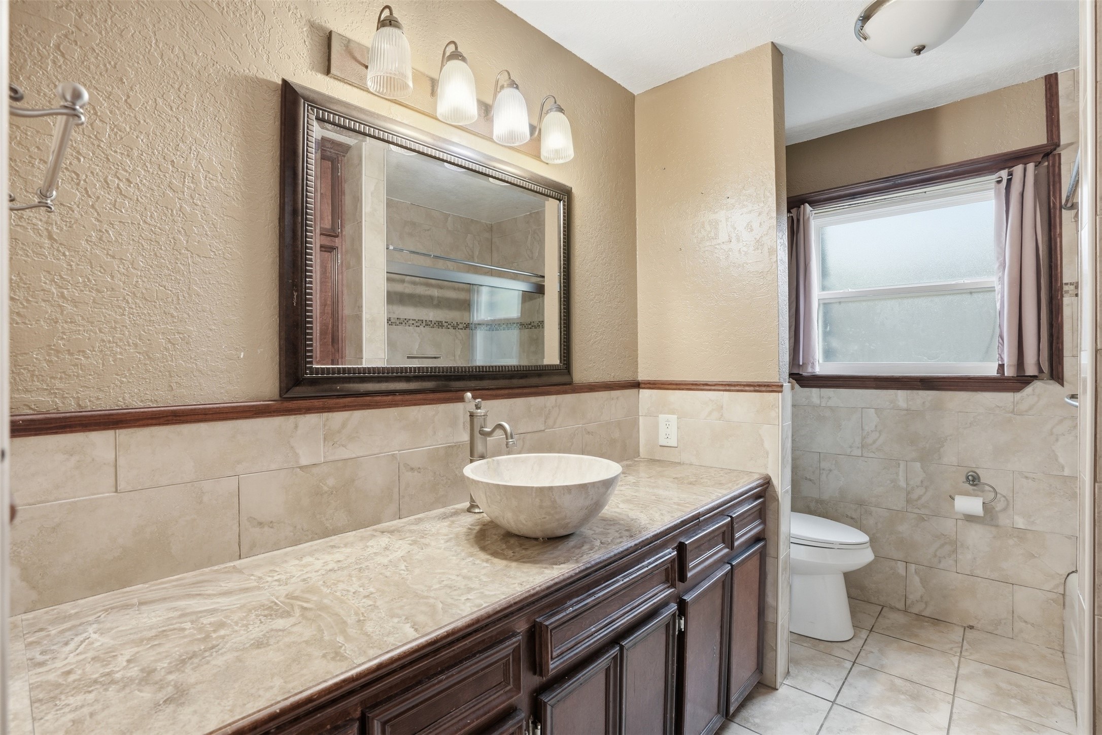 2605 Burke Road Pasadena, TX 77502 - Photo 22 of 29 a bathroom with a granite countertop sink a toilet and mirror