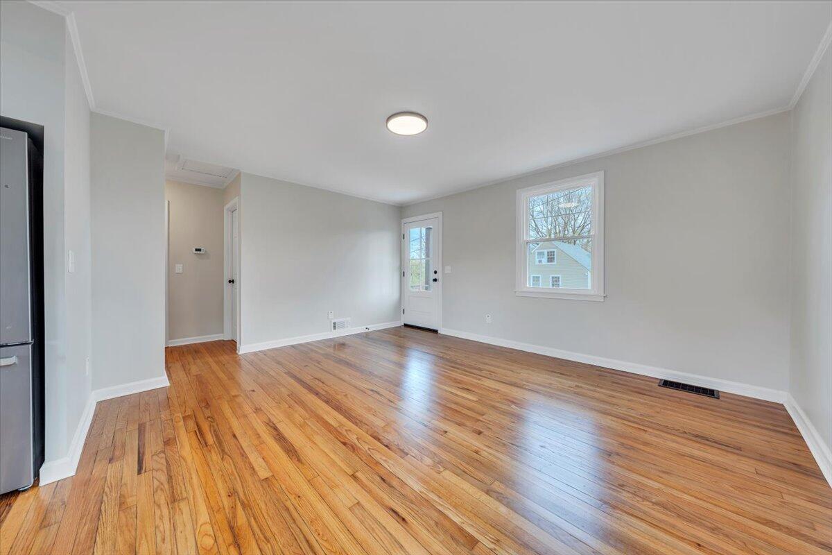 1004 26th Street Southwest Roanoke, VA 24015 - Photo 5 of 27 a view of an empty room with wooden floor and a window