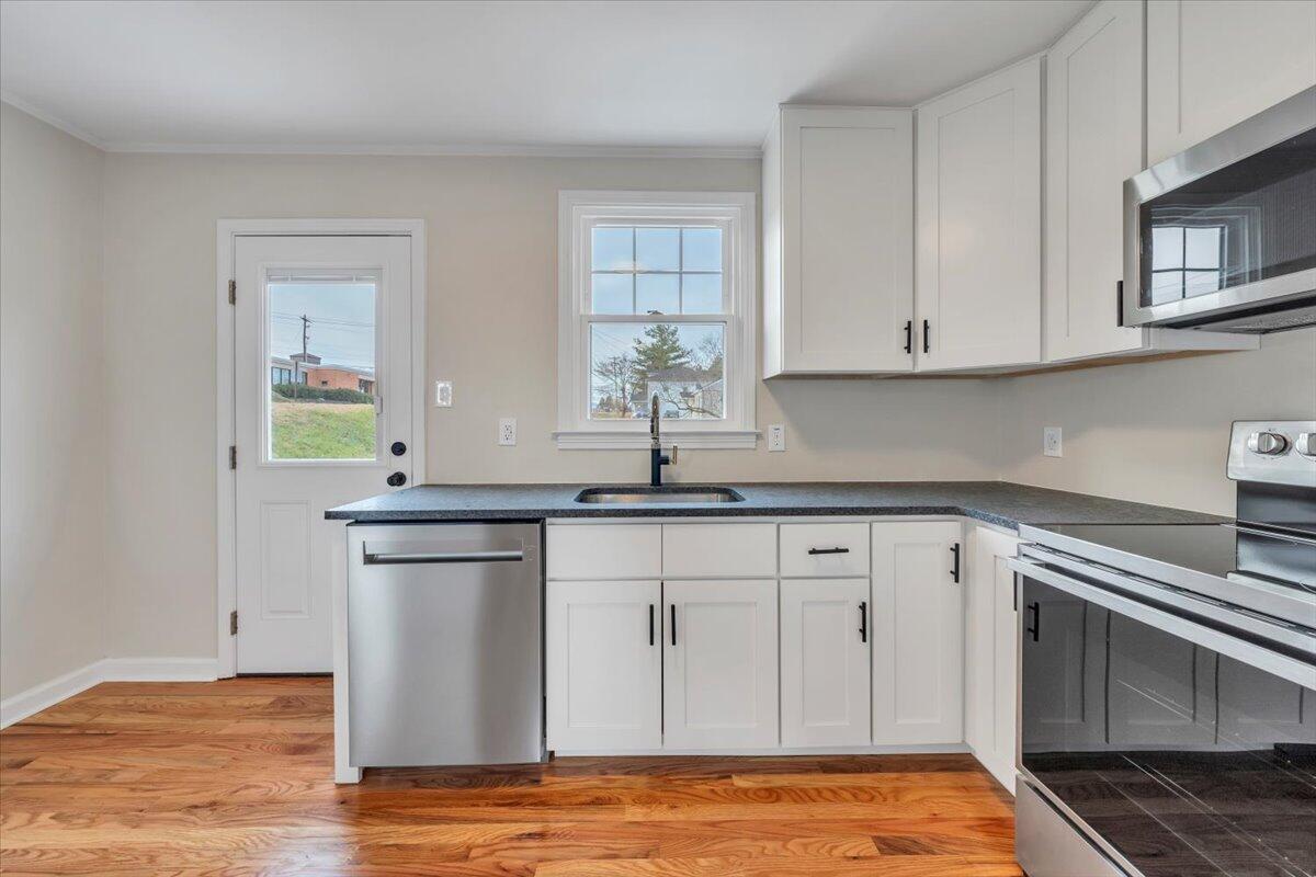 1004 26th Street Southwest Roanoke, VA 24015 - Photo 7 of 27 a kitchen with stainless steel appliances granite countertop a sink and a stove