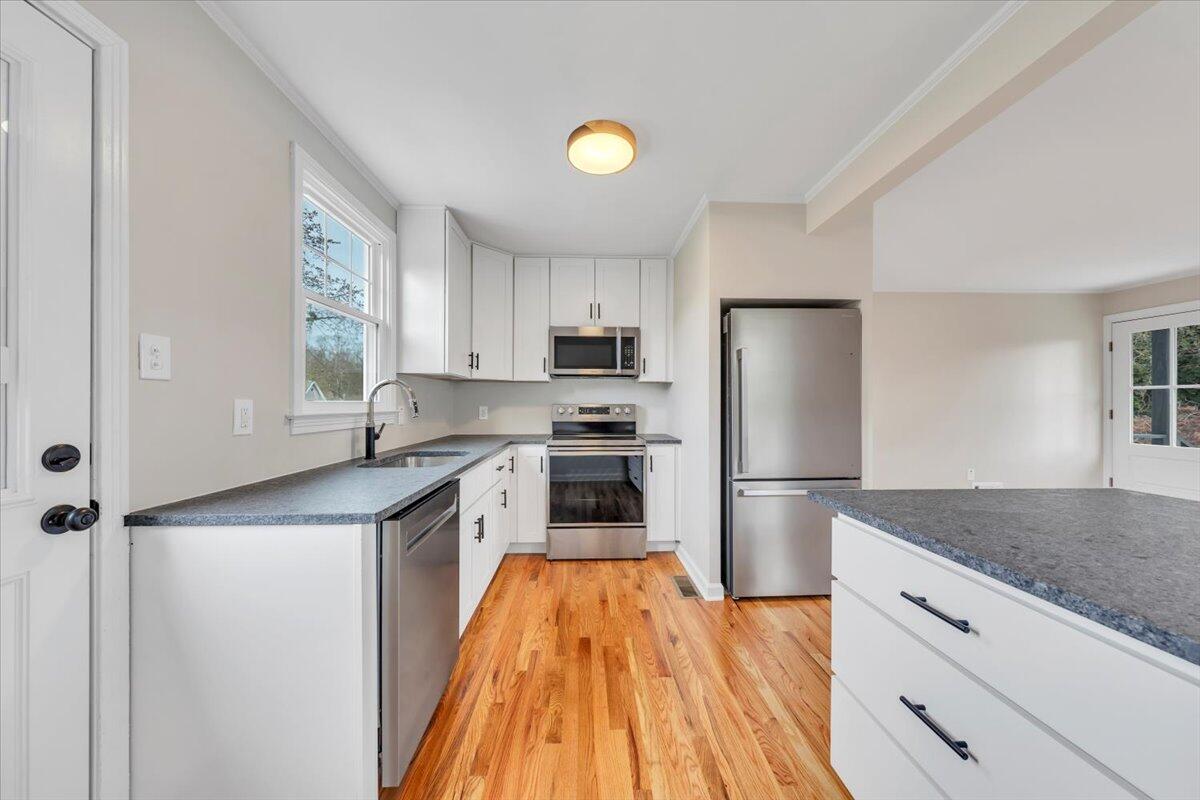 1004 26th Street Southwest Roanoke, VA 24015 - Photo 8 of 27 a kitchen with a refrigerator a microwave and wooden floor